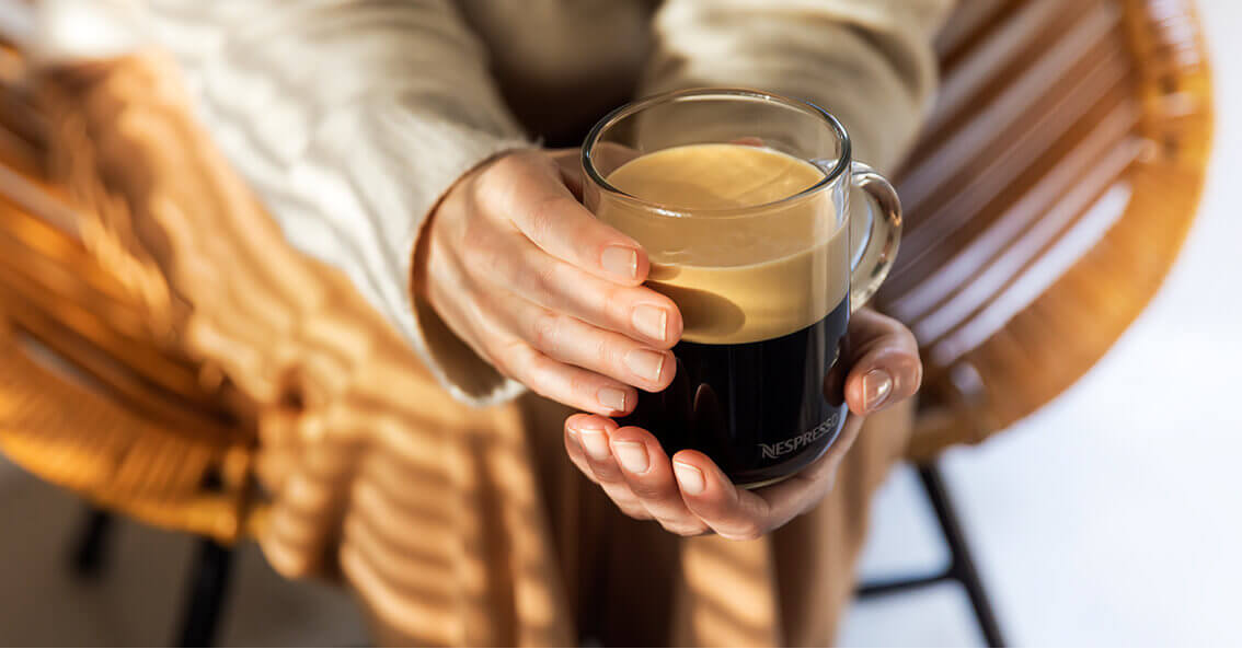 Mujer sosteniendo taza de café solo