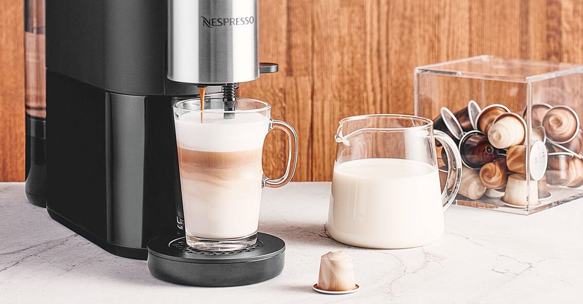 Taza de café con leche con máquina Nespresso