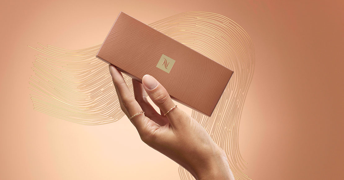 mano cogiendo caja con cápsulas de café