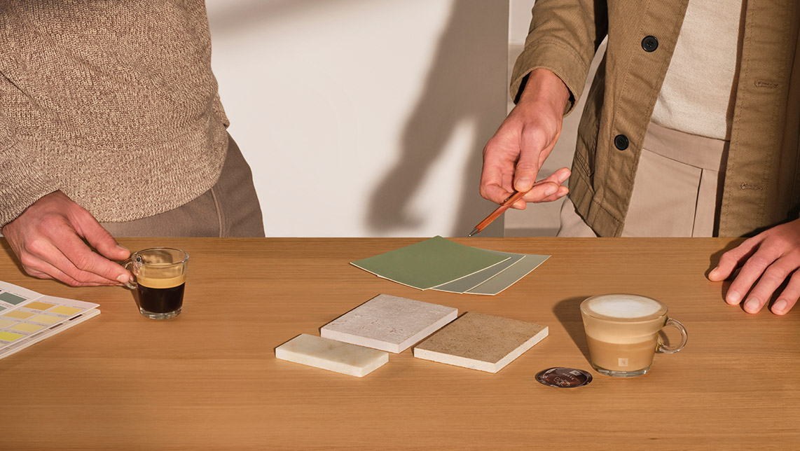 Hombre trabajando con colores y unos cafés en la mesa