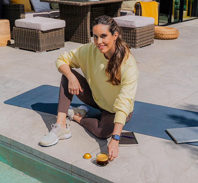 Mujer sentada en el suelo bebiendo café