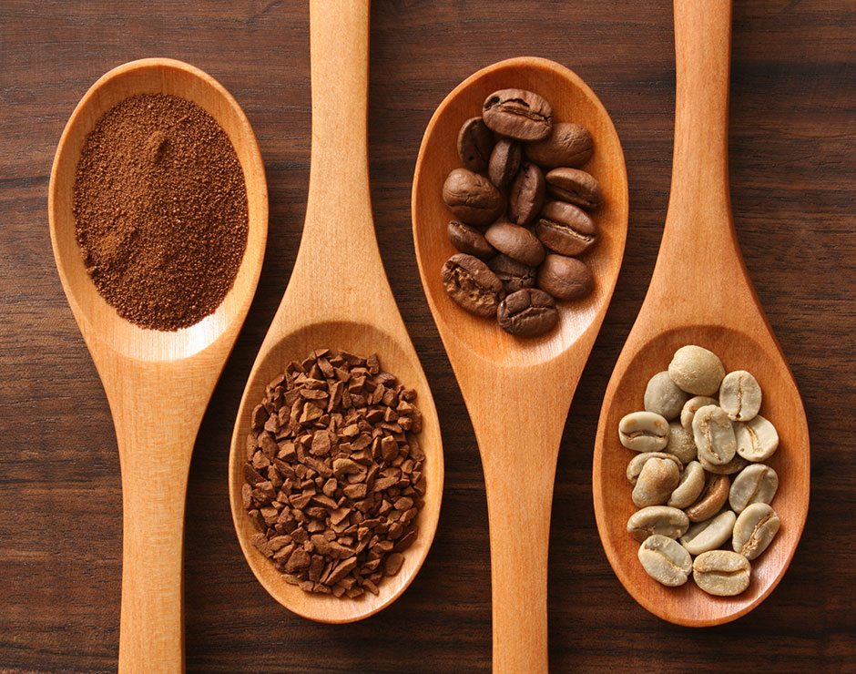 Cucharas de madera con granos de café en su interior