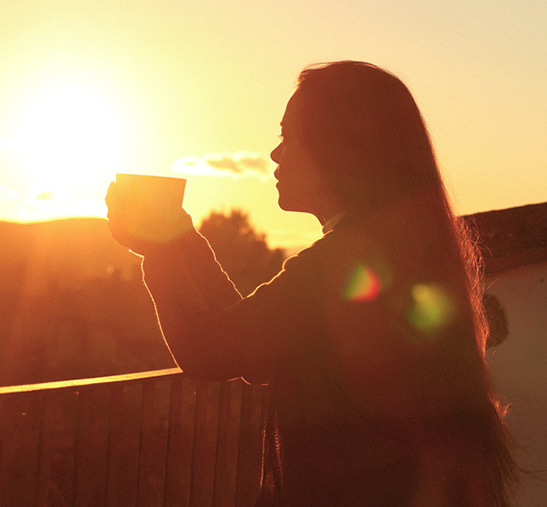 Mujer tomando un café Nespresso al atardecer