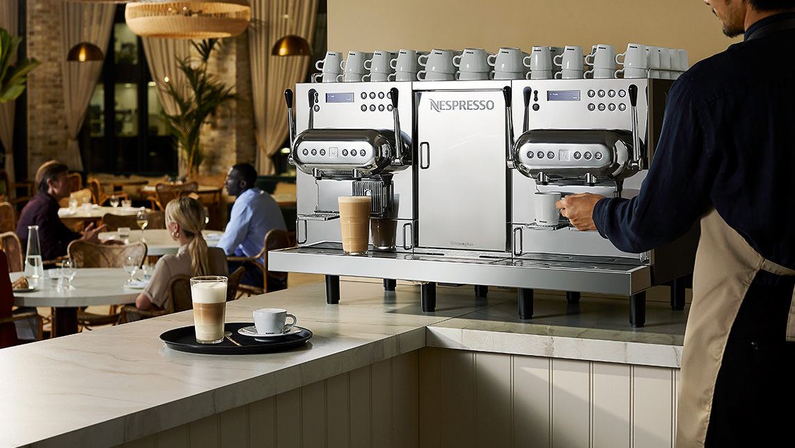 Barman usando una máquina de café profesional de Nespresso