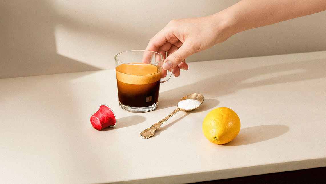 Mano recogiendo una taza de café Nespresso