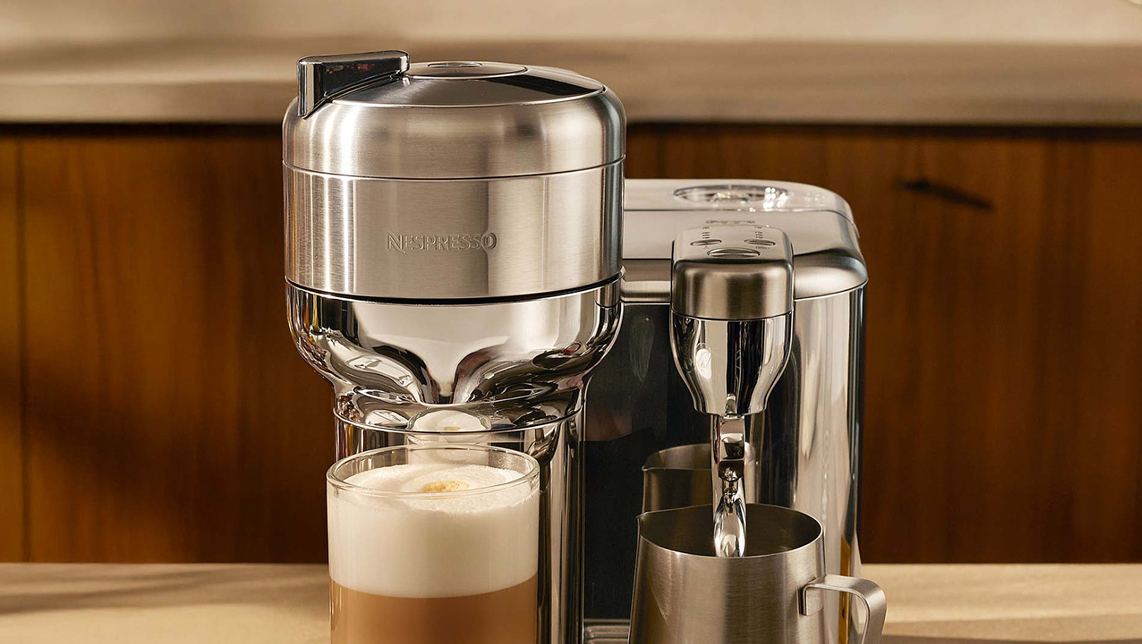 Cafetera cromada haciendo café con espuma