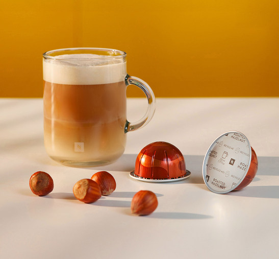 Cápsulas de café rojas junto a café con leche