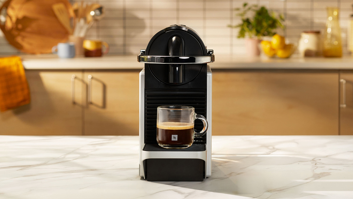 Máquina de color negro en mesa de mármol blanco