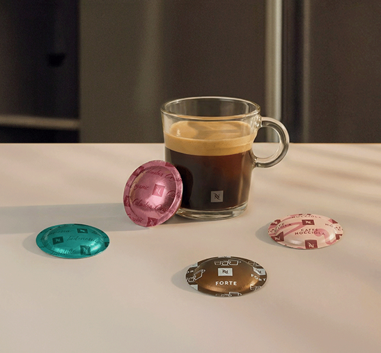 Taza de cristal con café junto a cápsulas Professional.