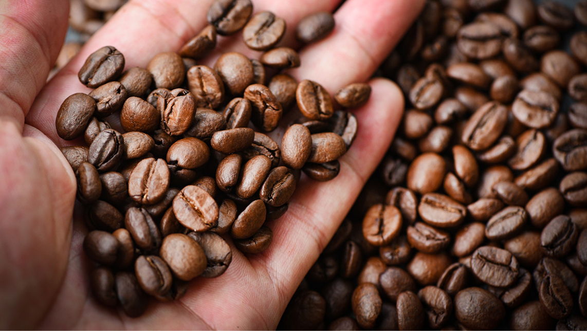 Granos de café sobre una mano.