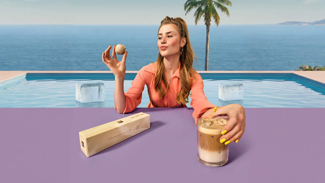 Mujer en una piscina con un vaso de iced latte