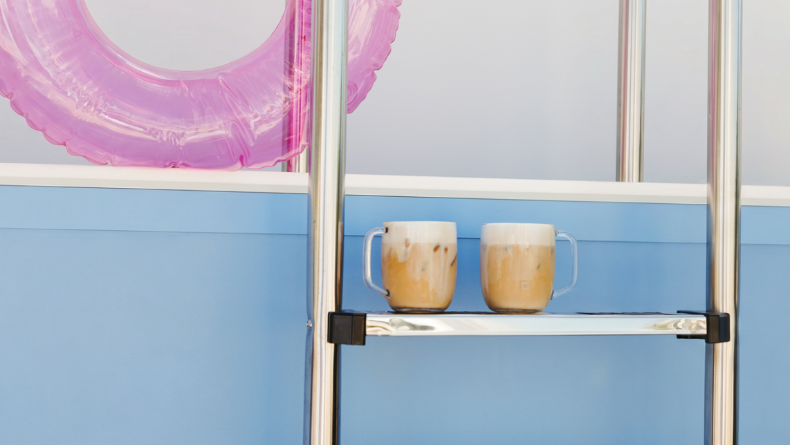 Dos cafés Nespresso sobre peldaño de piscina