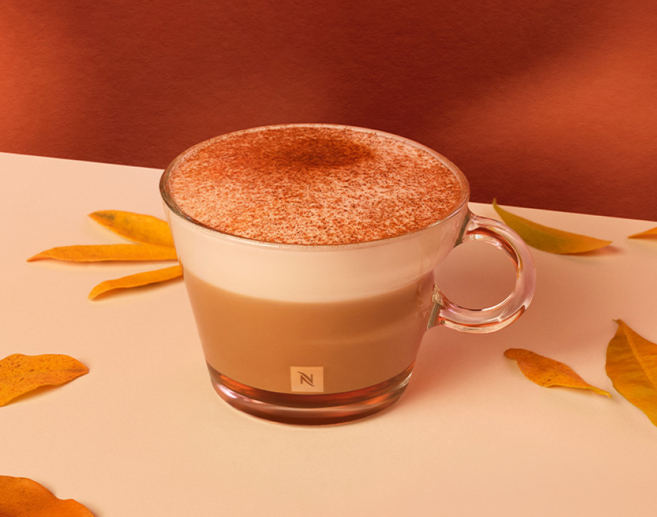 Taza de café con sabor a calabza y canela espolvoreada por encima