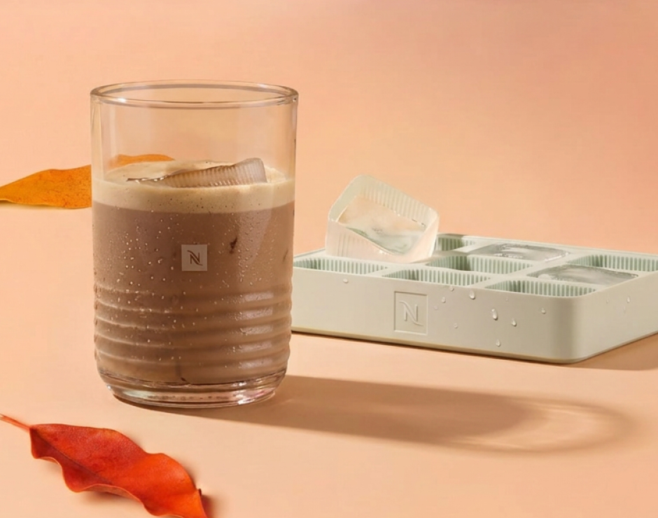 Taza de café junto a hielos en cubitera de la marca Nespresso