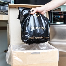 Nespresso Recycling bag being placed into the bulk recycling box