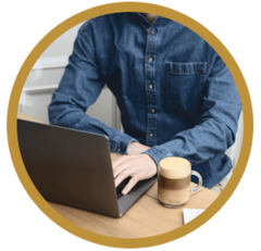 Man working on a laptop with a Nespresso Coffee in a brown circle