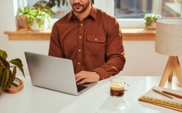 Working man with a laptop and a Nespresso Vertuo coffee 