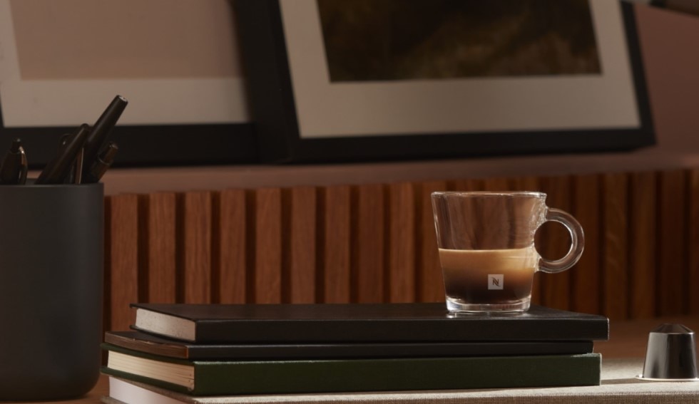 Nespresso Tasse mit einem Espresso auf einem Bücherstapel