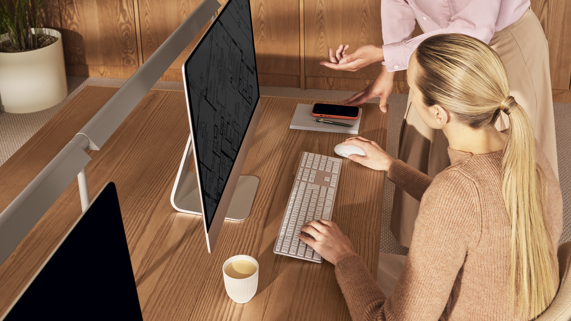 Employee working at desk with Nespresso coffee on the side