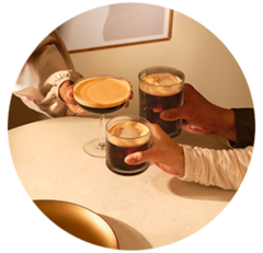 Man on the phone with a Nespresso espresso next to him