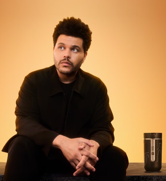 The Weeknd ao lado de copo térmico Nespresso Samra Origins