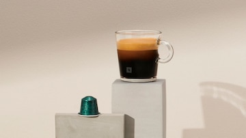 Imagem de uma xícara espresso VIEW da Nespresso e uma cápsula de café