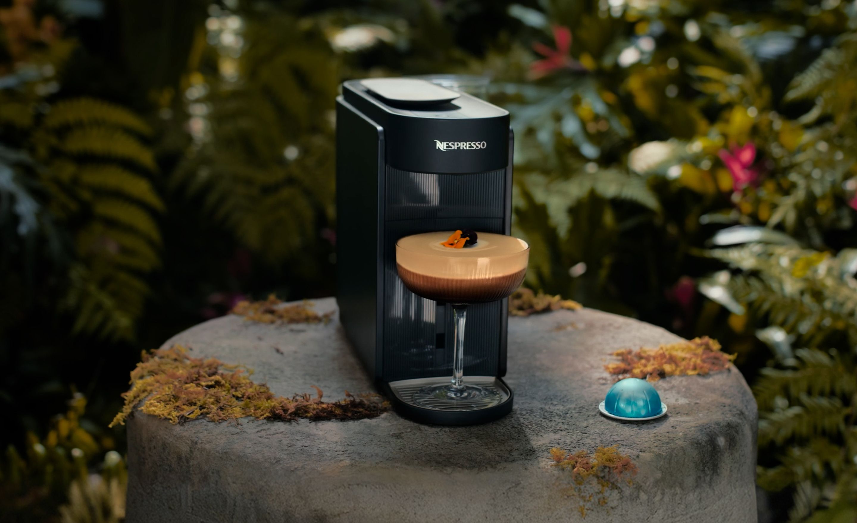 Dua Lipa enjoying coffee in modern interior with Nespresso Professional machines on table