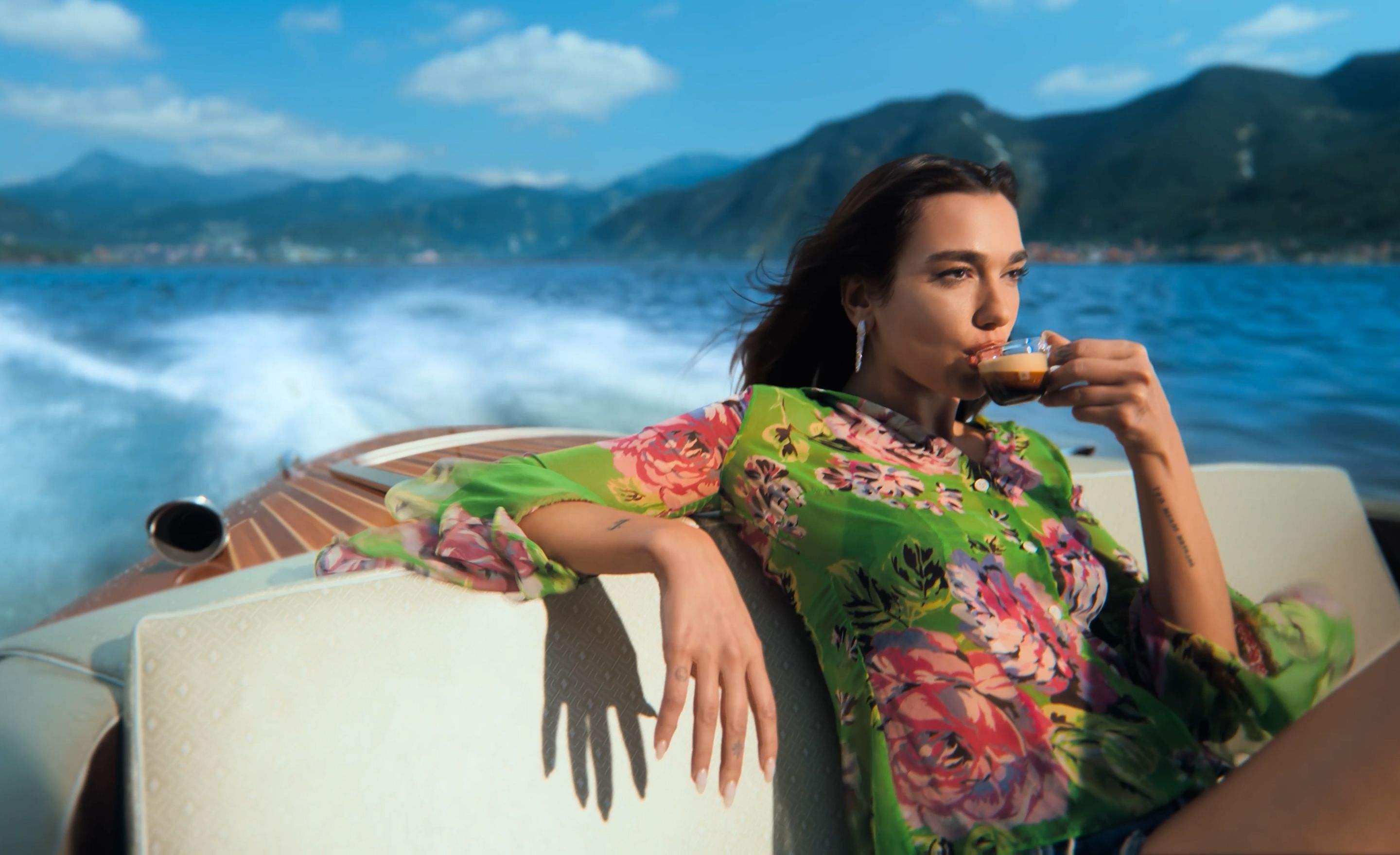 Dua Lipa enjoying coffee in modern interior with Nespresso Professional machines on table