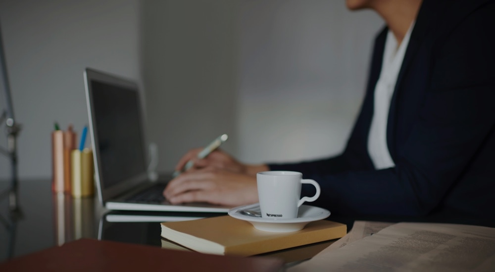 Kaffee steht neben dem Arbeitslaptop