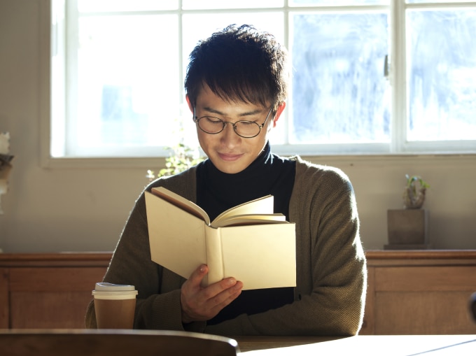 man reading with coffee cup on the table