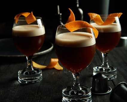3 bitter sweet cocktais in brandy glasses with an orange peel garnish
