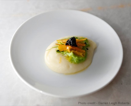 Silken Potato with Bottarga & Egg Yolk on a white plate